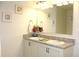 Bathroom featuring double sinks, granite counters, and framed seashell art at 5897 Soter Ln, Windermere, FL 34786