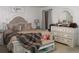 Charming bedroom featuring a tufted headboard, decorative pillows, and a vintage-style dresser at 5897 Soter Ln, Windermere, FL 34786