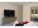 Bright bedroom featuring a modern TV console, light grey walls and a large mirror at 5897 Soter Ln, Windermere, FL 34786