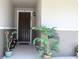 Inviting front porch featuring a decorative door, potted plants, and a charming exterior light fixture at 5897 Soter Ln, Windermere, FL 34786