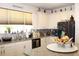 Kitchen boasts white cabinets, granite countertops, a mosaic backsplash, and modern appliances for cooking at 5897 Soter Ln, Windermere, FL 34786