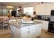 Open kitchen with granite counters, island, and modern white cabinets with views to the dining area at 5897 Soter Ln, Windermere, FL 34786