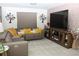 A sectional sofa with yellow pillows and a large screen TV makes a cozy space to watch movies at 5897 Soter Ln, Windermere, FL 34786