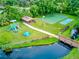 Aerial view of community park featuring playground, picnic shelter, sports court and bridge over water at 650 Woodridge Drive, Fern Park, FL 32730