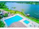 Aerial view of a luxurious community pool area with chaise lounges and serene lake views at 650 Woodridge Drive, Fern Park, FL 32730