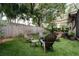 Cozy backyard with a fire pit lounge area, lush green lawn, and privacy fence at 7 Westchester Dr, Kissimmee, FL 34744
