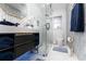 Modern bathroom featuring a vanity with black cabinets, a walk-in glass shower, and stylish geometric tile accents at 7 Westchester Dr, Kissimmee, FL 34744