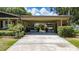 Long driveway with a carport and lush landscaping at 7 Westchester Dr, Kissimmee, FL 34744