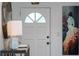 Bright entryway features a white door with decorative glass and a stylish console table with marble lamp and art at 7 Westchester Dr, Kissimmee, FL 34744