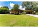 Lovely single-story home with a brick exterior, a well-manicured lawn, and a screened patio at 7 Westchester Dr, Kissimmee, FL 34744