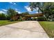 Well-maintained home with a long driveway, green lawn, and established landscaping at 7 Westchester Dr, Kissimmee, FL 34744