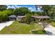 Well-maintained brick home with a screened-in porch, mature landscaping, and a covered carport at 7 Westchester Dr, Kissimmee, FL 34744