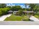 Charming brick home with a screened lanai, lush landscaping, and convenient carport at 7 Westchester Dr, Kissimmee, FL 34744
