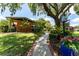 Inviting home exterior featuring a brick pathway and lush, manicured landscaping at 7 Westchester Dr, Kissimmee, FL 34744