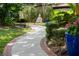 Serene garden pathway featuring a Buddha statue, lush greenery, and brick-lined walkway at 7 Westchester Dr, Kissimmee, FL 34744