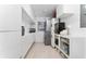 Bright laundry room with white cabinets, appliances, and countertop space at 7 Westchester Dr, Kissimmee, FL 34744