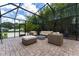 Inviting screened-in patio with comfortable wicker furniture and a cozy fire pit at 7 Westchester Dr, Kissimmee, FL 34744
