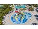 Aerial view of a water park featuring colorful slides, sprinklers, and shaded seating areas at 7876 Marlow Pl, Kissimmee, FL 34746