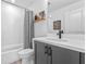 Cozy bathroom with a shower-tub combo, modern gray vanity, black fixtures, and decorative wall art at 8460 Sperry St, Orlando, FL 32827