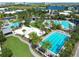 Aerial view of community pools, palm trees, a sand volleyball court, and lush landscaping at 8460 Sperry St, Orlando, FL 32827