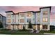 Modern townhome with a charming exterior, beautiful landscaping, and a well-lit entryway creating a welcoming ambiance at 8460 Sperry St, Orlando, FL 32827