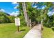 Charming South Bay community path with warning sign and a quaint wooden bridge amidst greenery at 8812 S Bay Dr, Orlando, FL 32819