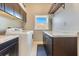 Bright laundry room featuring white washer and dryer, granite countertops, and ample cabinetry at 8812 S Bay Dr, Orlando, FL 32819