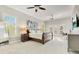 Spacious main bedroom featuring a sitting area, desk, ceiling fans, and a large bed bathed in natural light at 8812 S Bay Dr, Orlando, FL 32819