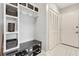 Mudroom with a built-in bench, shelves and hooks, plus closet and white plank door at 8812 S Bay Dr, Orlando, FL 32819