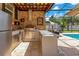 Poolside brick outdoor kitchen with stainless steel appliances and ample counter space for entertaining at 8812 S Bay Dr, Orlando, FL 32819