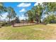 Community playground with swings, slides, and a picnic table surrounded by a black fence and trees at 8812 S Bay Dr, Orlando, FL 32819