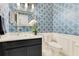 Stylish powder room featuring a glass vessel sink, black vanity and bold patterned wallpaper for a modern look at 8812 S Bay Dr, Orlando, FL 32819