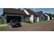 Modern home with a dark finished garage and a private driveway, showcasing contemporary design at 9940 Black Bear Ln, Winter Garden, FL 34787