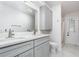 Modern bathroom with double sink, white cabinets, quartz countertops, and walk-in shower at 1013 Silcox Branch Cir, Oviedo, FL 32765