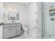 Well-lit bathroom featuring glass shower, grey vanity, toilet, and marble countertops at 1013 Silcox Branch Cir, Oviedo, FL 32765