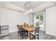 Bright dining room featuring modern light fixture, wood table and six chairs, and large window at 1013 Silcox Branch Cir, Oviedo, FL 32765