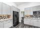 Modern kitchen with gray cabinetry, stainless steel appliances, granite countertops, and stylish backsplash at 1013 Silcox Branch Cir, Oviedo, FL 32765