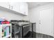 Laundry room featuring white cabinets, stainless steel washer and dryer, and tiled floors at 1013 Silcox Branch Cir, Oviedo, FL 32765