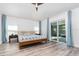 Main bedroom with hardwood floors, ceiling fan, large glass patio doors, and blue curtains at 1013 Silcox Branch Cir, Oviedo, FL 32765