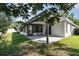 Rear view of home with enclosed patio and a lawn surrounded by mature trees at 1013 Silcox Branch Cir, Oviedo, FL 32765