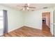 Bright bedroom featuring hardwood floors, a ceiling fan, and a window for natural light at 10247 Mason Loop, Clermont, FL 34711