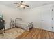 Comfortable bedroom with ceiling fan, wood laminate flooring, and door to hallway at 10247 Mason Loop, Clermont, FL 34711