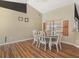 Cozy dining area featuring wood floors and a window with blinds, complemented by neutral walls and decorative wall art at 10247 Mason Loop, Clermont, FL 34711