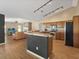 Open-concept kitchen with modern appliances and lighting, seamlessly connected to the living room with a stone fireplace feature at 10247 Mason Loop, Clermont, FL 34711