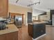 Open kitchen features wood cabinets, stainless steel appliances, and a center island with breakfast bar at 10247 Mason Loop, Clermont, FL 34711