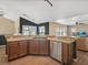 Well-appointed kitchen featuring stainless steel appliances, wood cabinetry, and sleek countertops overlooking an open living space at 10247 Mason Loop, Clermont, FL 34711