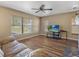 Cozy living room with large windows offering lots of natural light and laminate wood floors at 10247 Mason Loop, Clermont, FL 34711
