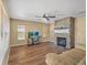 Open living area featuring laminate flooring, a ceiling fan, and stone fireplace at 10247 Mason Loop, Clermont, FL 34711