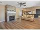 Inviting living room features a stone fireplace, ceiling fan, and wood laminate flooring at 10247 Mason Loop, Clermont, FL 34711