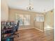 Bright living area featuring wood floors, large window, and a chandelier-style light fixture, creating a welcoming and airy space at 10247 Mason Loop, Clermont, FL 34711